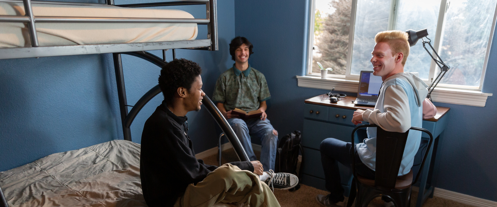 College boys sit and chat in their dorm room.