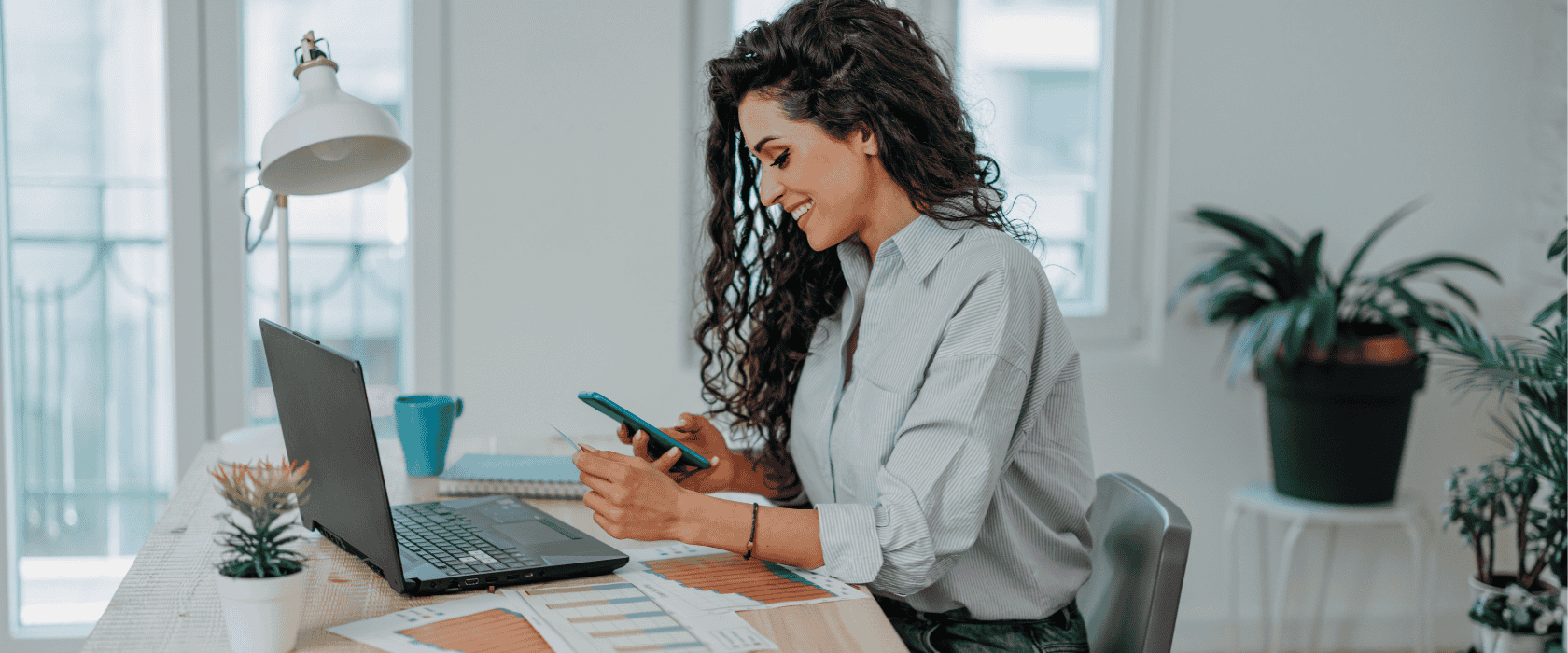 Woman on her computer and phone with her debit card