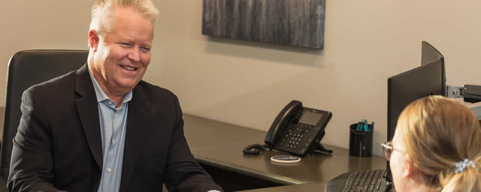 Dave Kochenberger with a client at a desk going over paperwork.