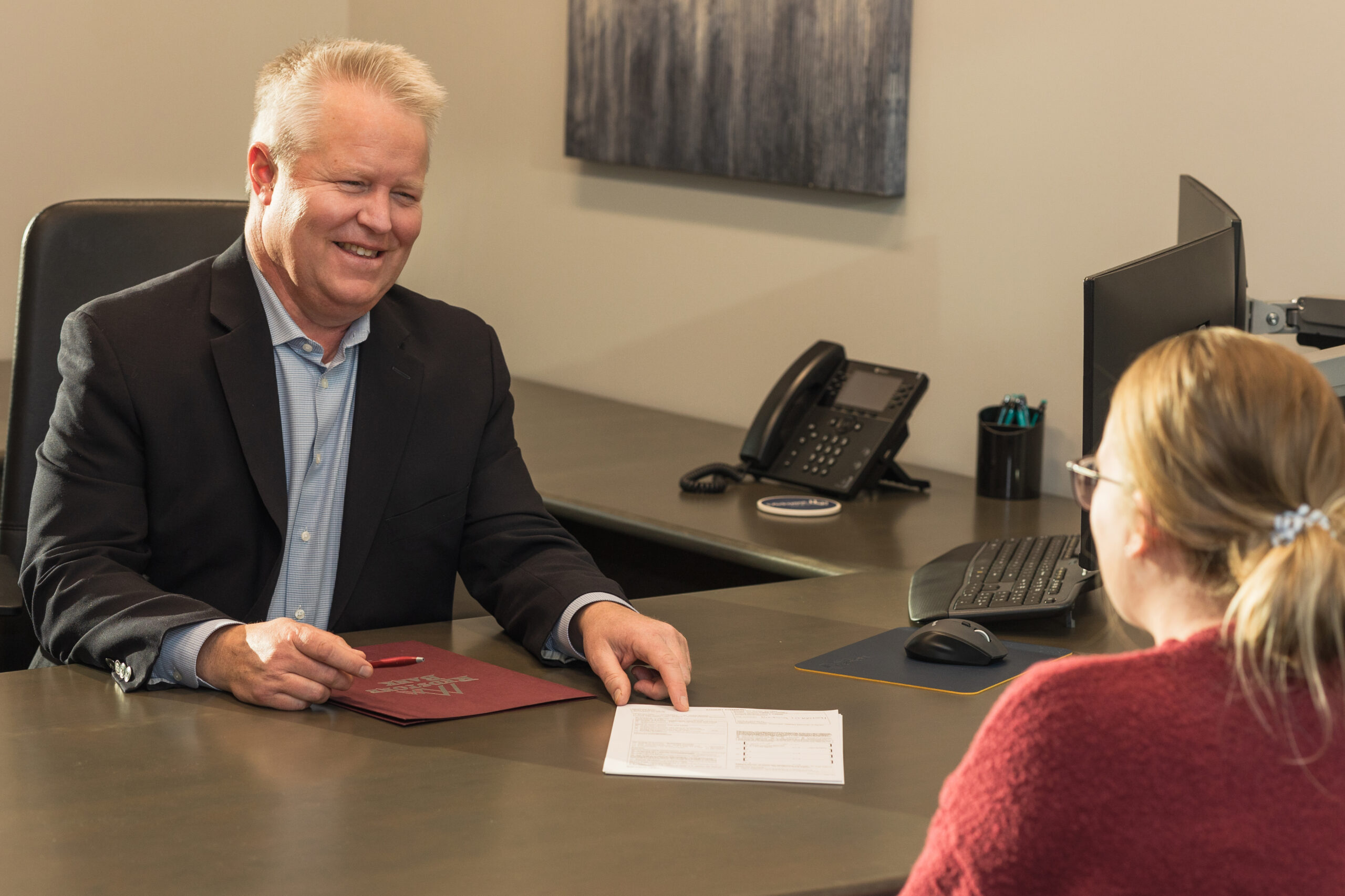 Dave Kochenberger with a client at a desk going over paperwork.