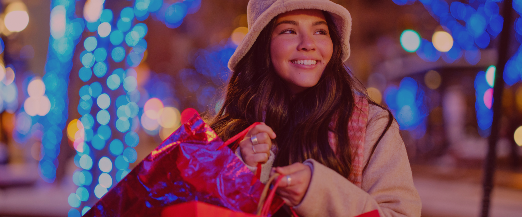 Young woman shopping outdoors at Christmas time holding shopping bags