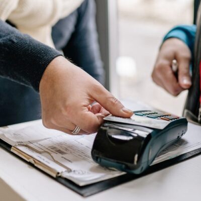 Customer using contactless debit card to pay for purchases.