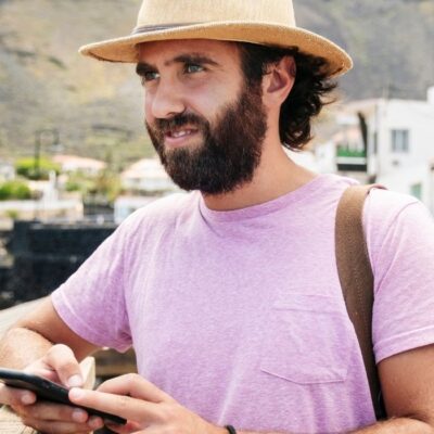 Man traveling and on his phone checking his bank account with his mobile app.