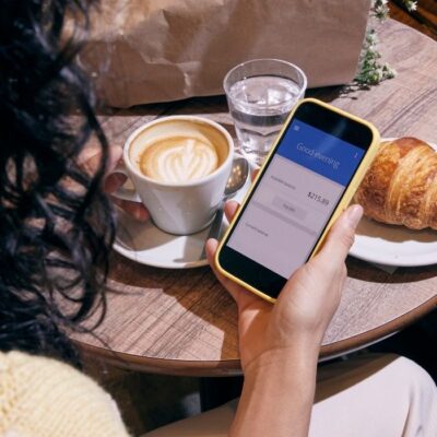 Woman checking her account balance on her mobile banking app at a restaurant.