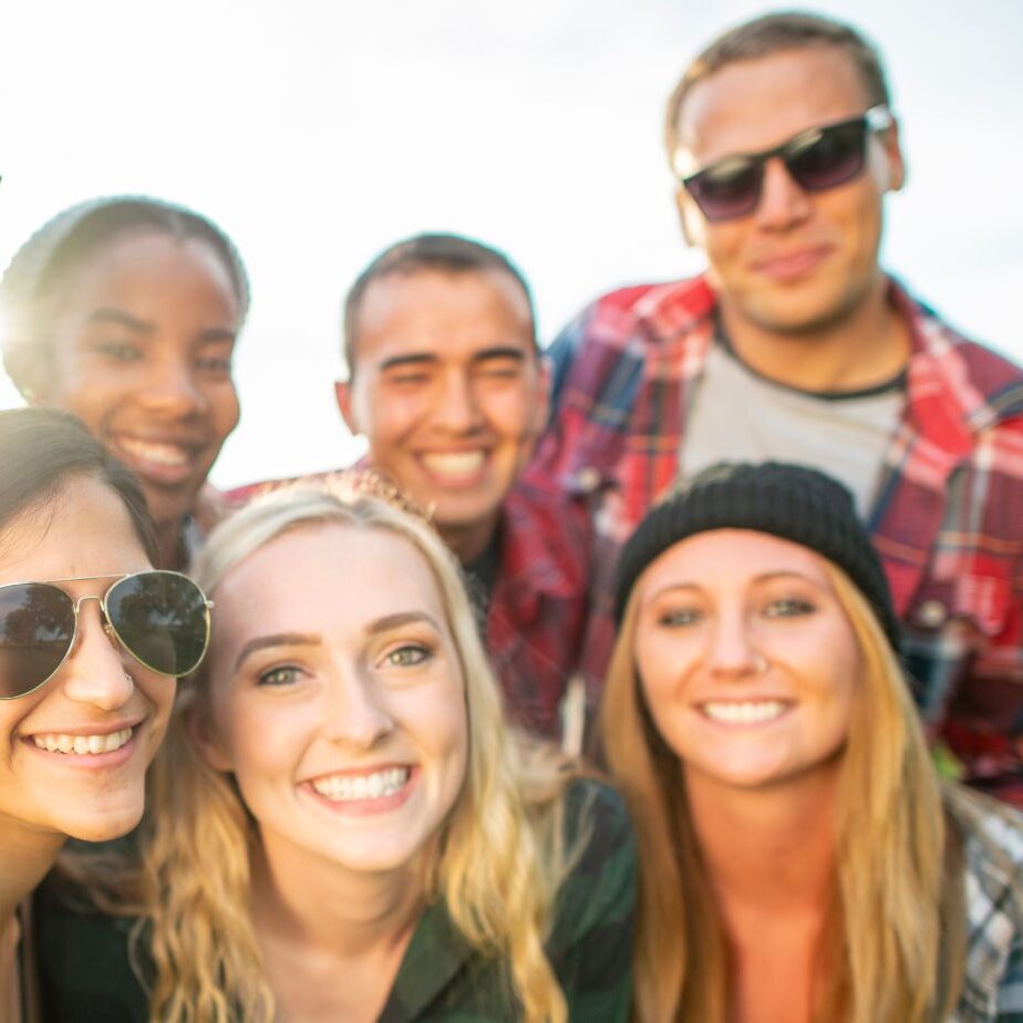 Young adults smiling for picture outside during the fall.